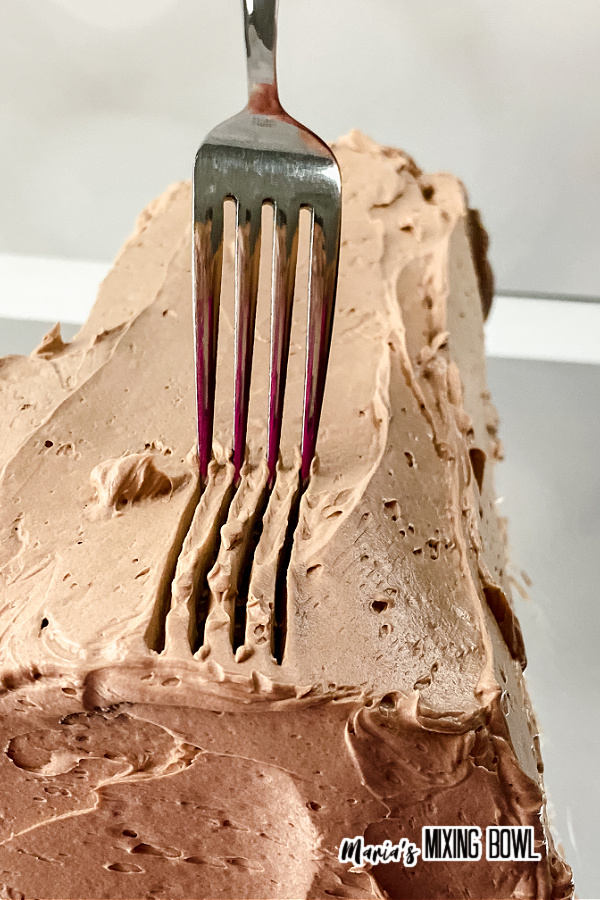Closeup shot of fork creating the bark pattern in the yule log frosting