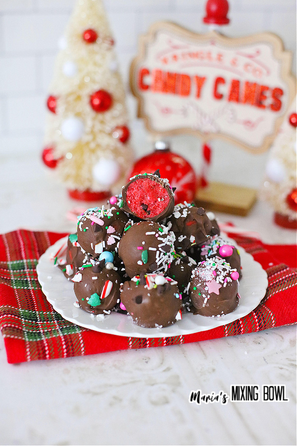 Stack of chocolate peppermint truffles on plate with Christmas signs in background