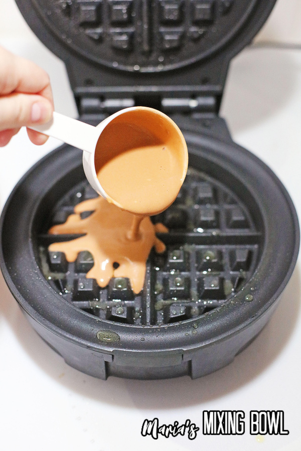 Waffle batter being poured into waffle maker