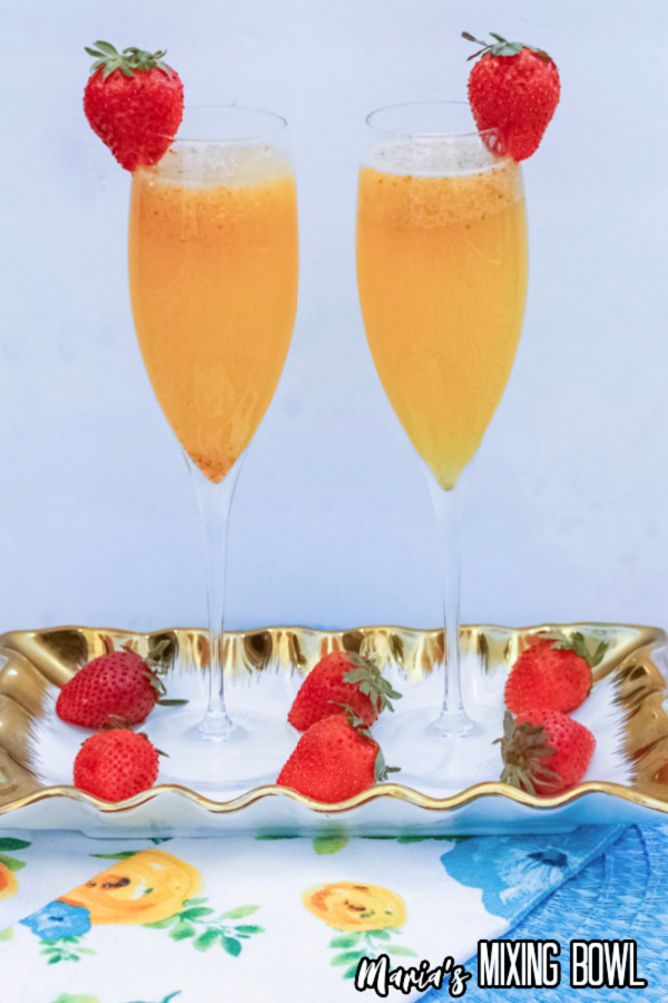 Two flutes filled with strawberry orange mimosas