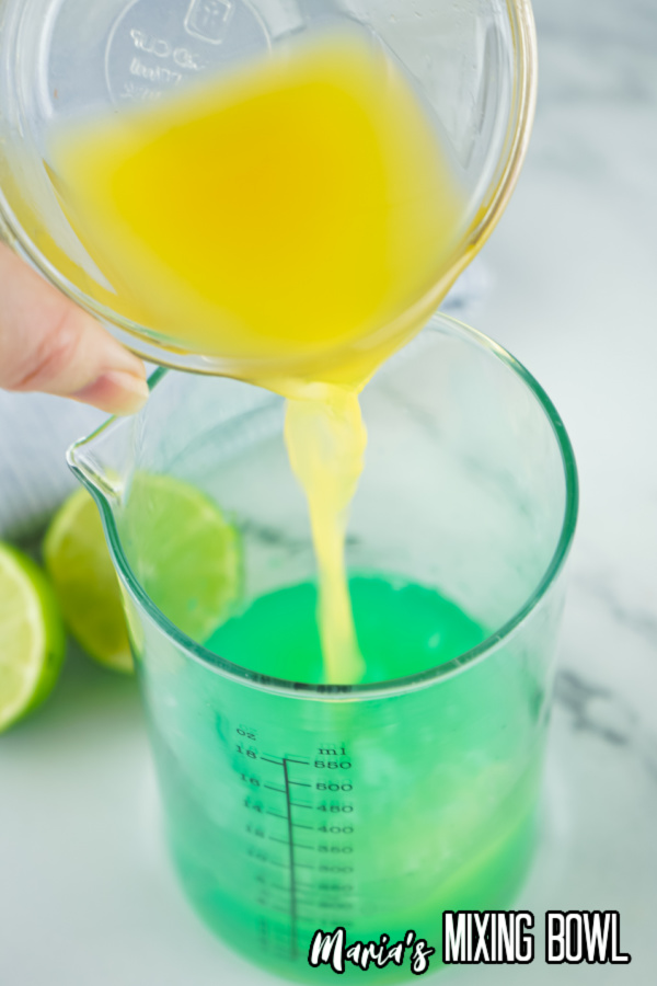Orange juice being poured into liquid measuring cup