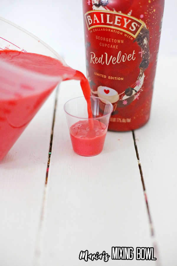 Jello shot mixture being poured into shot glass