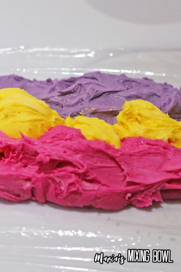 PInk, yellow, and purple frosting on plastic wrap