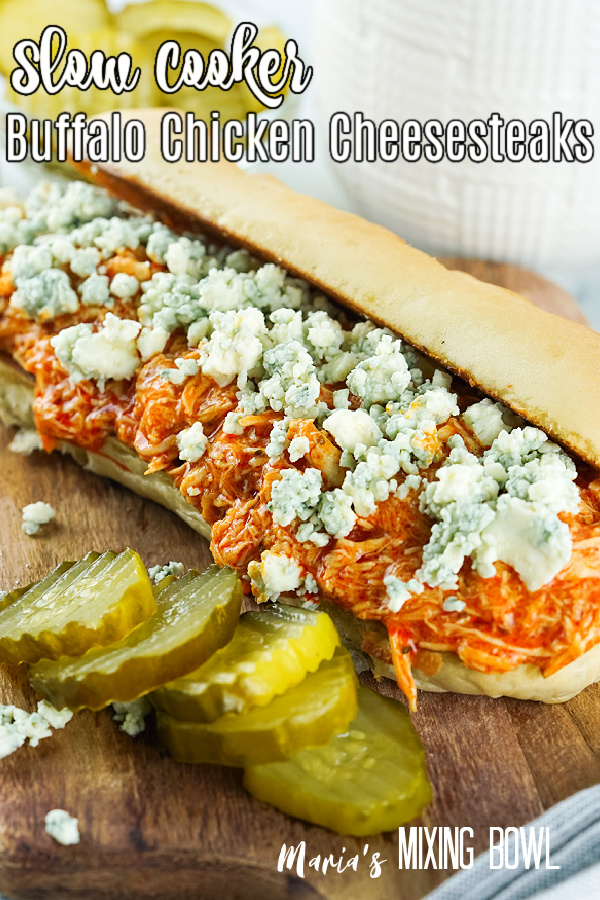Slow Cooker Buffalo Chicken Cheesesteaks on a board with pickles and blue cheese