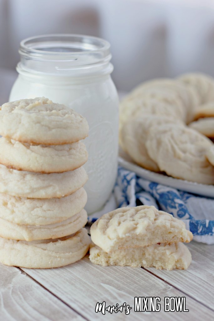 Closeup shot of Amish sugar cookies stacked atop one another next to glass of milk