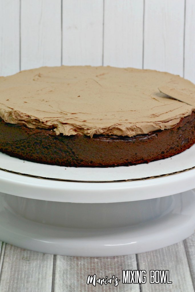 chocolate layer cake with frosting spread on it