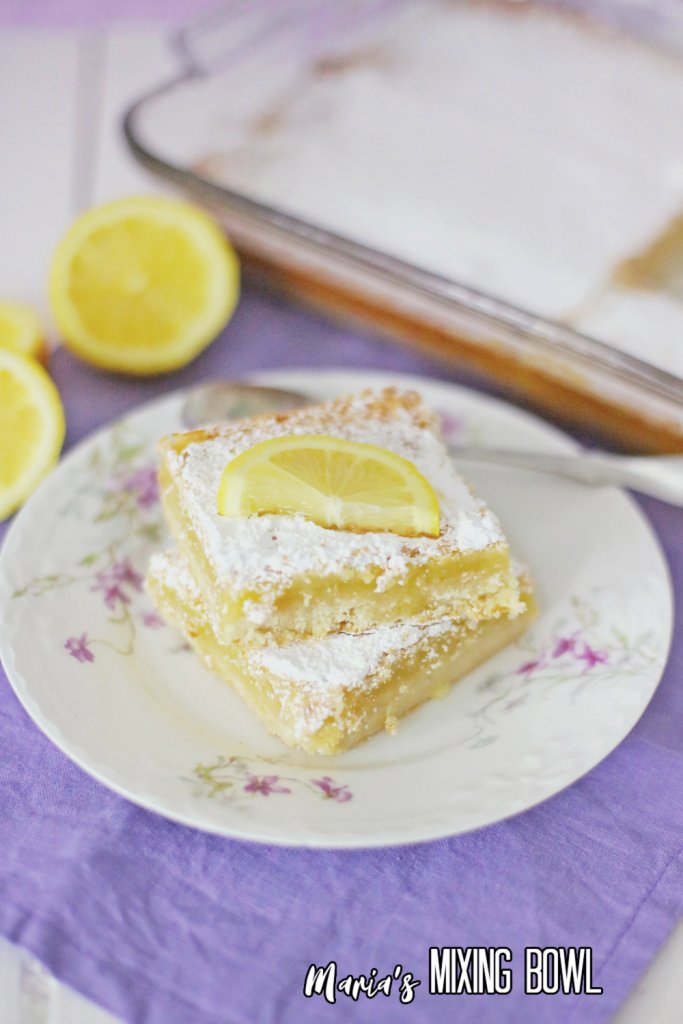 Closeup shot of two lemon bars stacked atop one another on plate