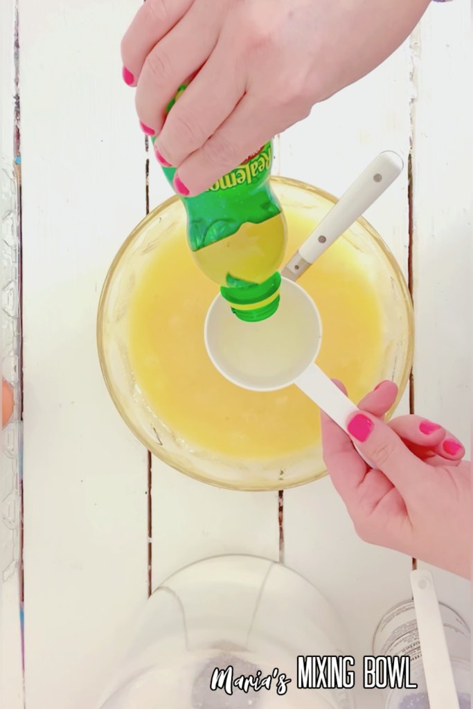 Overhead shot of lemon juice being poured into custard mixture