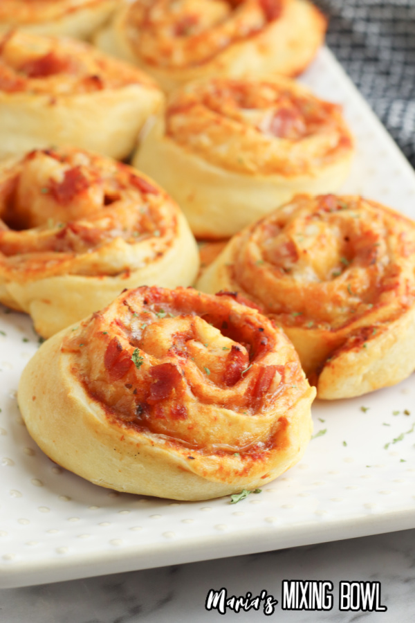 Closeup shot of baked pepperoni pizza pinwheels on plate