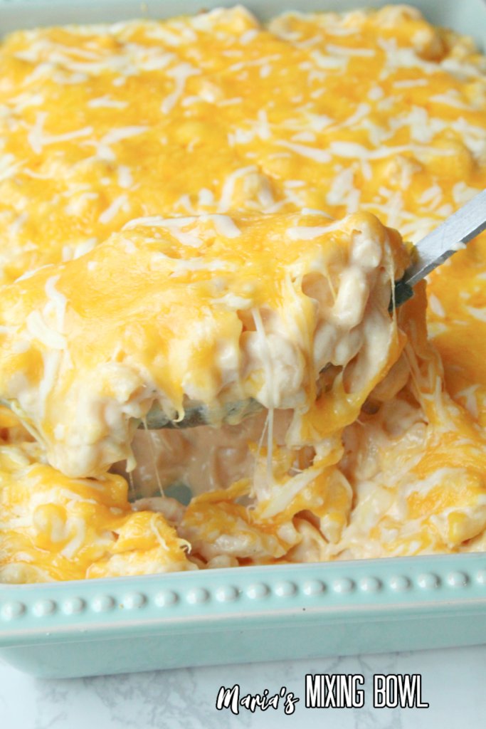 a big spoon of Creamy Baked Mac and Cheese taken from a blue casserole dish