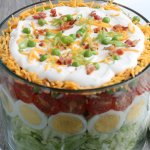 Seven Layer Salad on a grey table with white plates