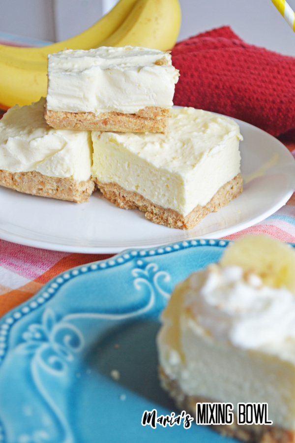 Banana pudding cheesecake bars stacked atop one another on plate