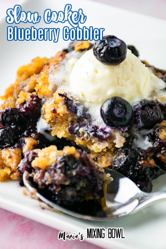 Slow Cooker Blueberry Cobbler with a scoop of ice cream and a spoon on plate