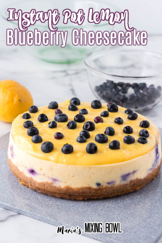 Instant pot lemon blueberry cheesecake on table with bowl of blueberries in background
