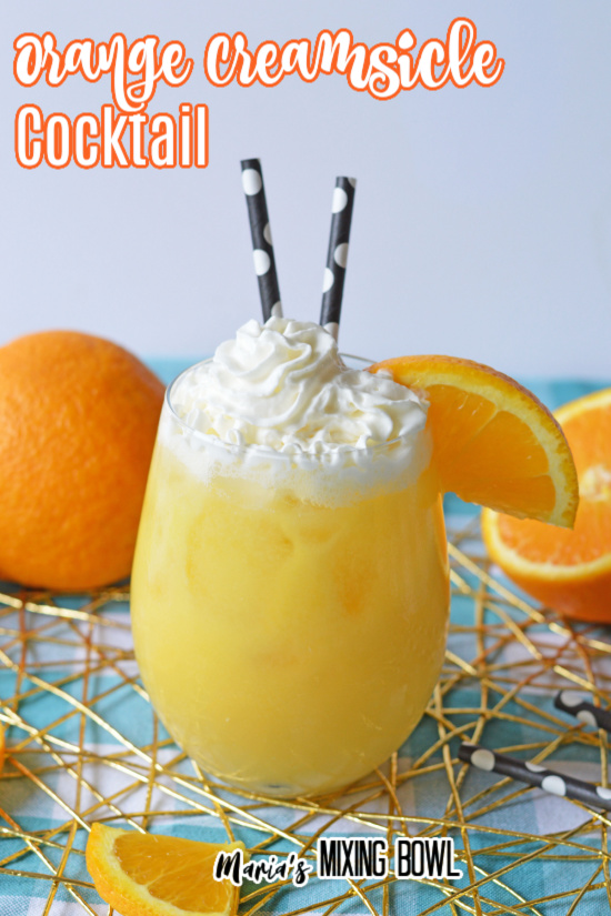 Orange creamsicle alcoholic drink garnished with whipped cream and orange wedge