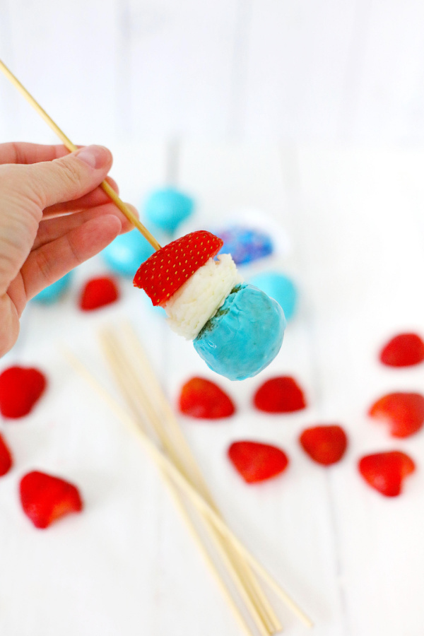 Donut hole, frosting, and strawberry on kabob