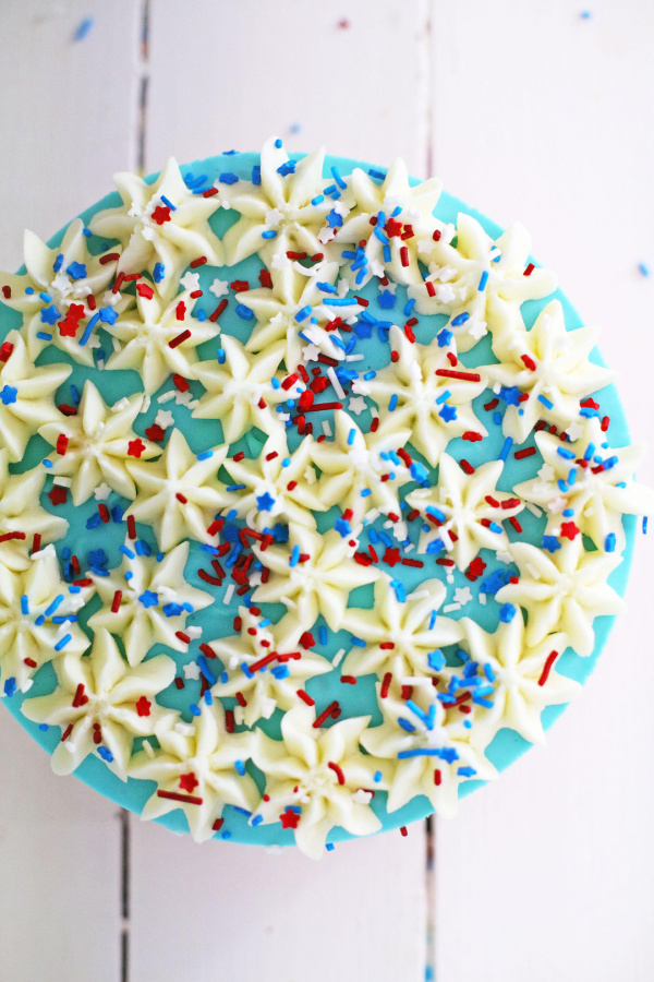 Overhead shot of patriotic kool aid cheesecake decorated with frosting in stars and sprinkles