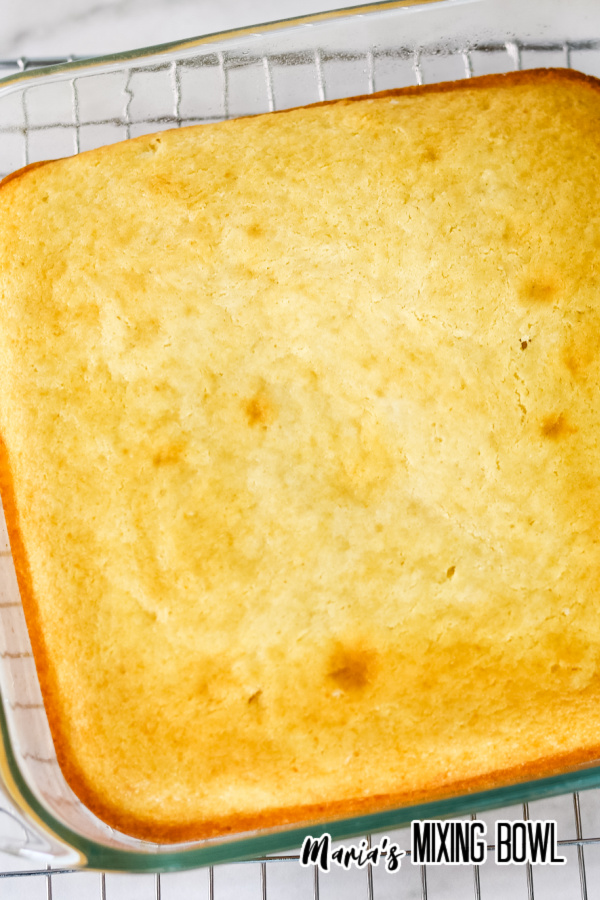 cake in a glass baking pan removed from the oven on a wire rack