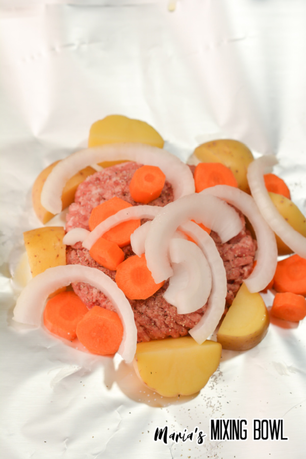 Ground beef, carrots, potatoes,and onions on foil 