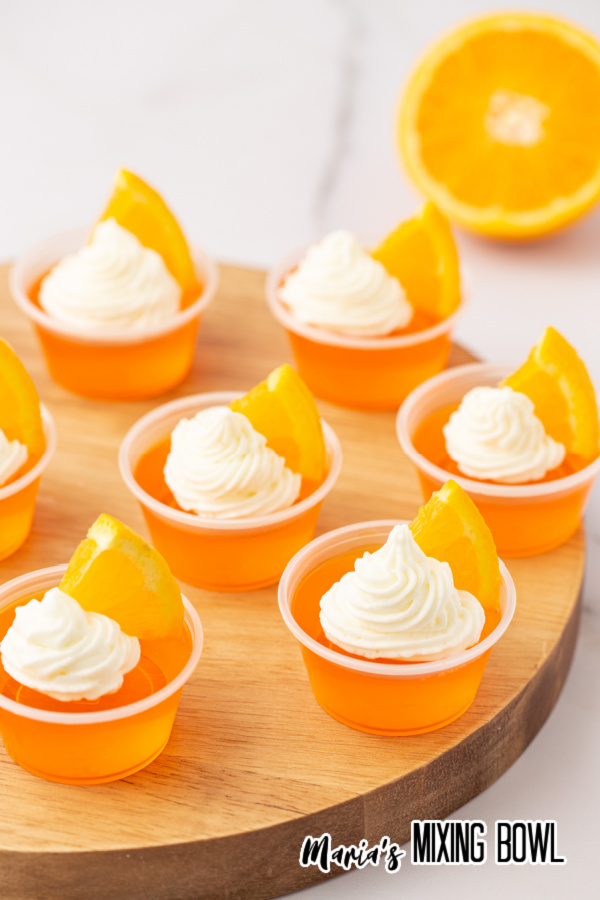 Orange creamsicle Jello shots on wooden board