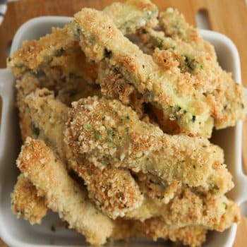 close up image of baked zucchini sticks in a white bowl