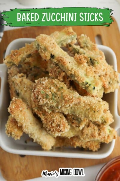 close up image of baked zucchini sticks in a white bowl