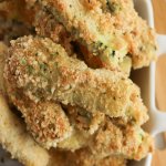 close up image of baked zucchini sticks in a white bowl with text for pinterest