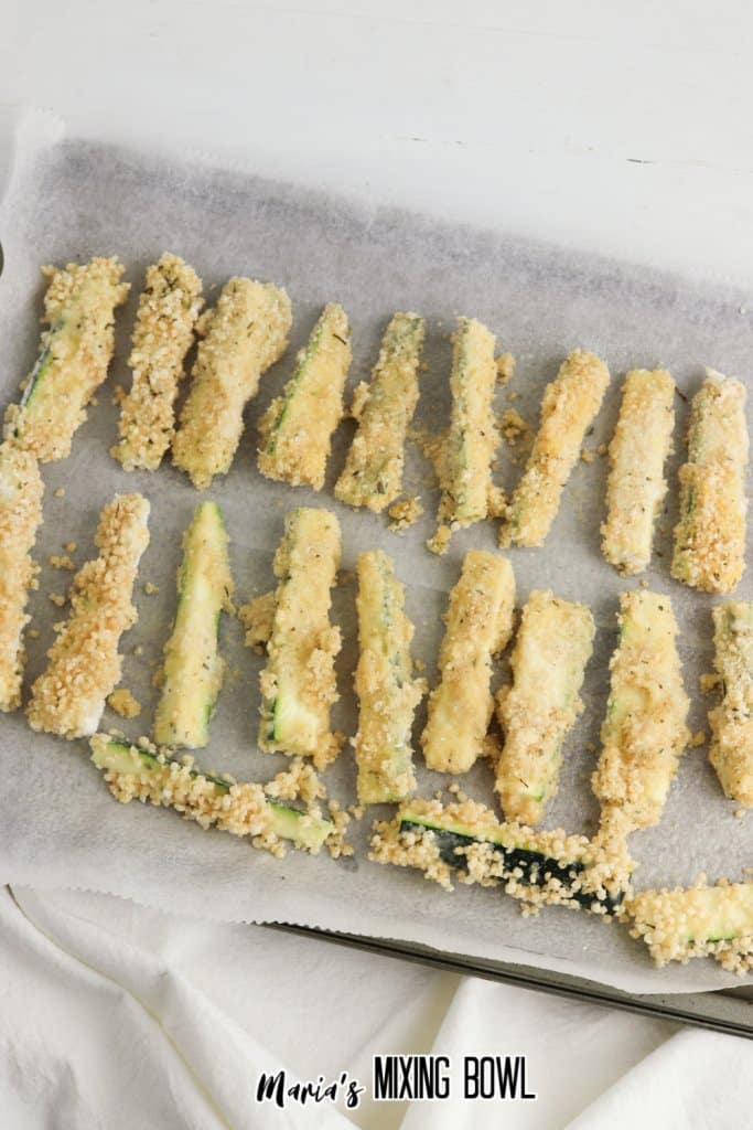 breaded fingers on a parchment lined baking sheet