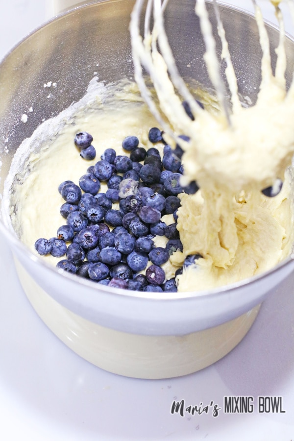 batter and blueberries in a stainless steel mixing bowl
