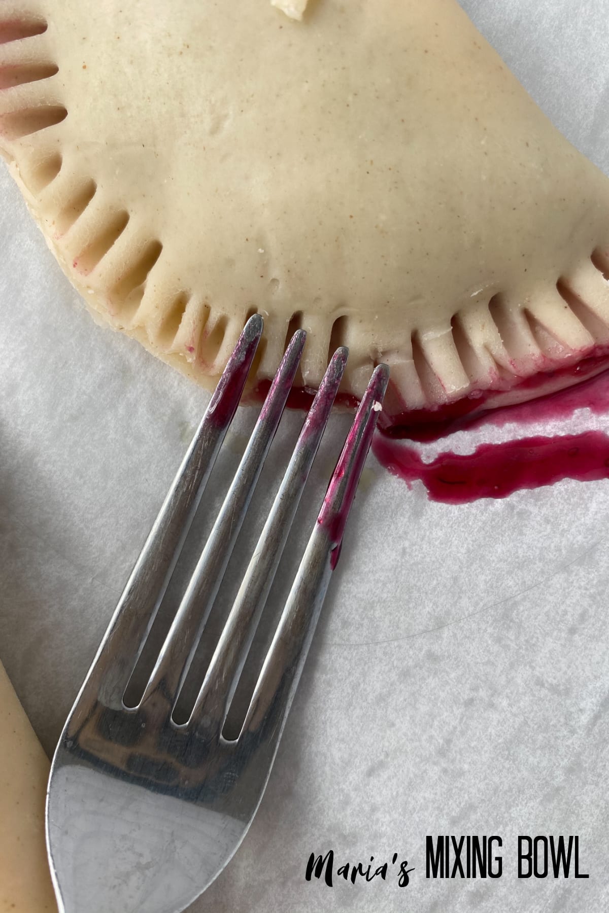 crimping the edge of a pastry with a fork