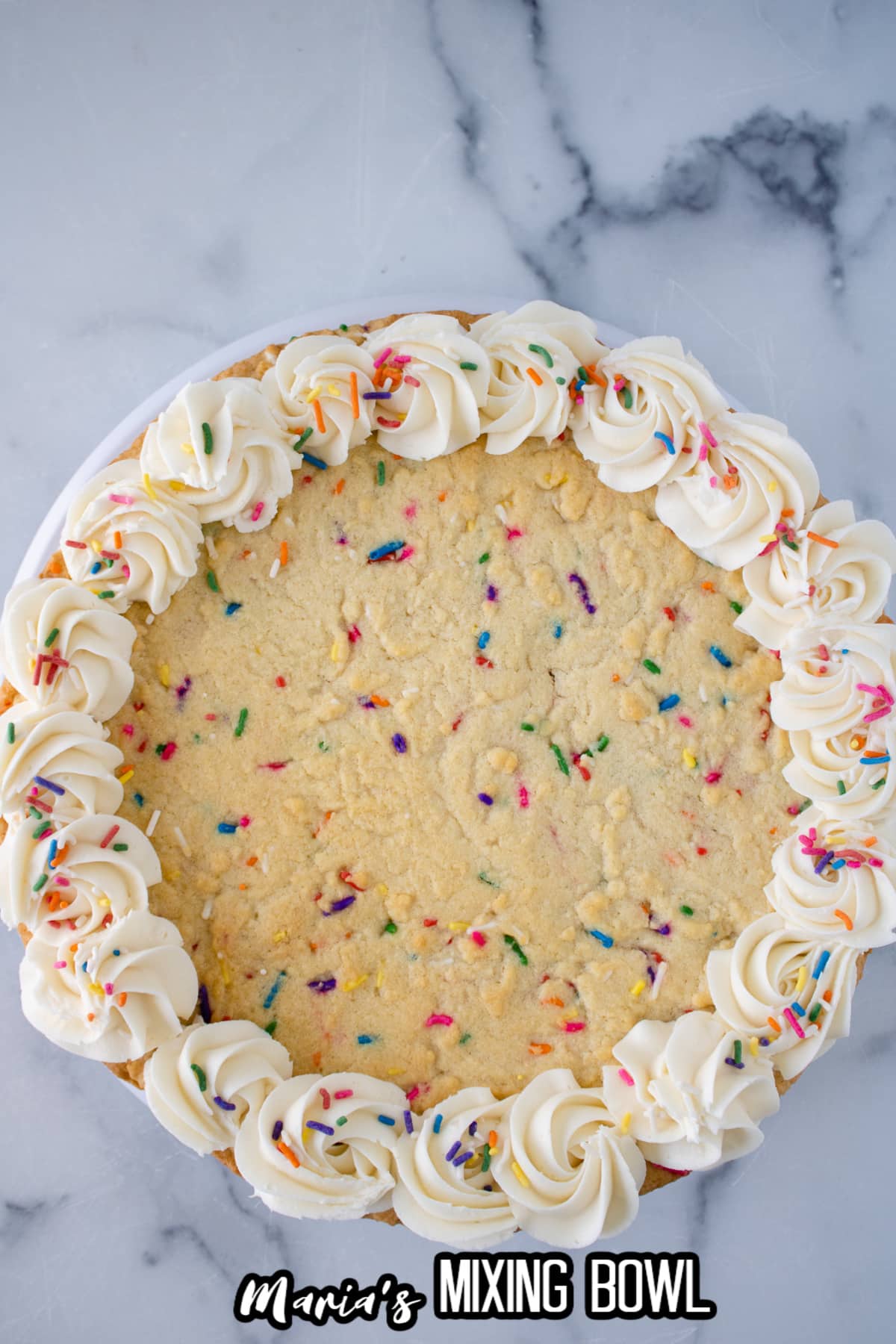 whole funfetti cookie cake on a marble counter