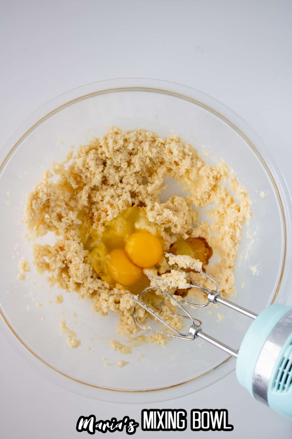 eggs, butter and sugar mixed in a glass mixing bowl