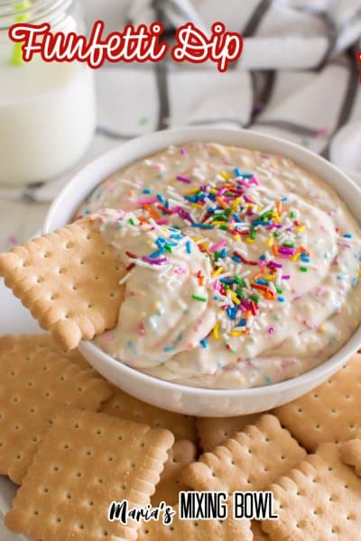 bowl of funfetti dip on a platter with cookies with the name in text