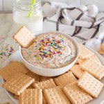 bowl of funfetti dip on a platter with cookies with the name in text