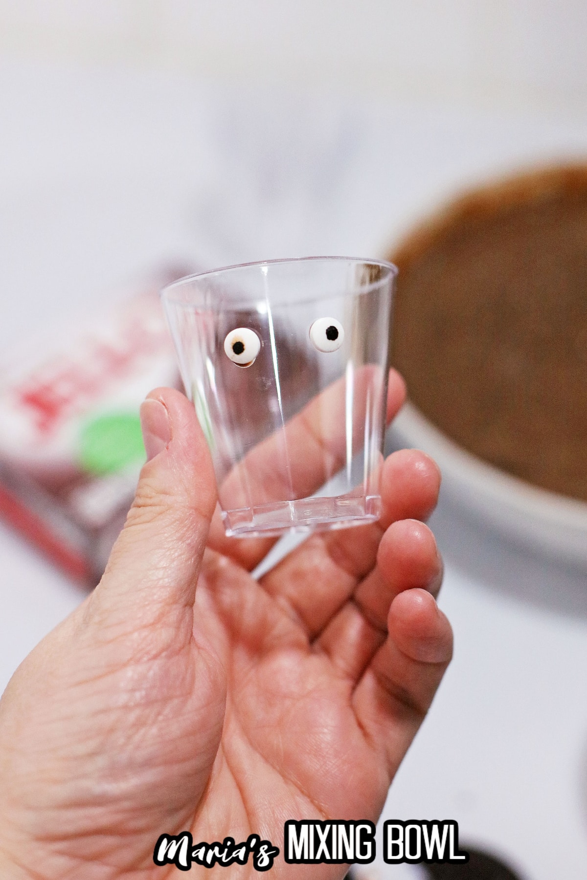 candy eyes stuck on a pudding shot cup