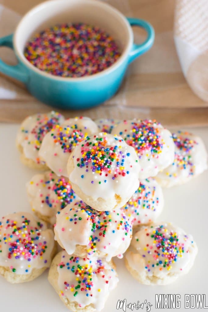 Italian Sprinkle Cookies stacked in a pyramid on a white table