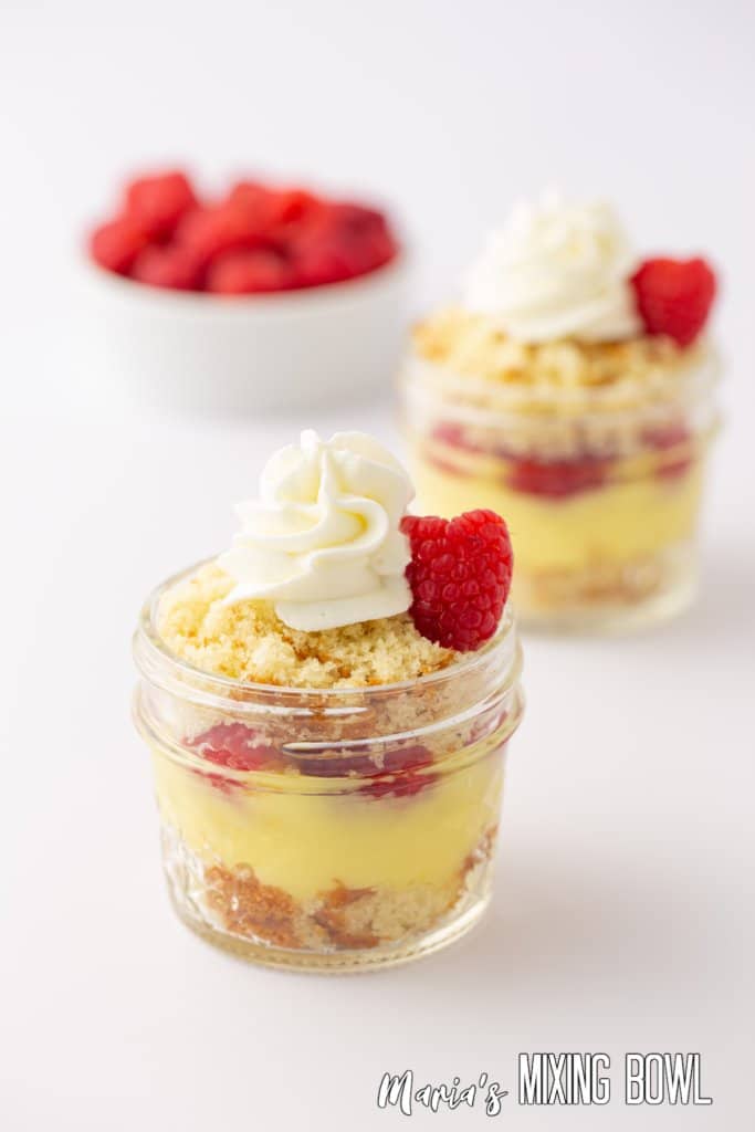 close up of two lemon mason jar trifles on a white background