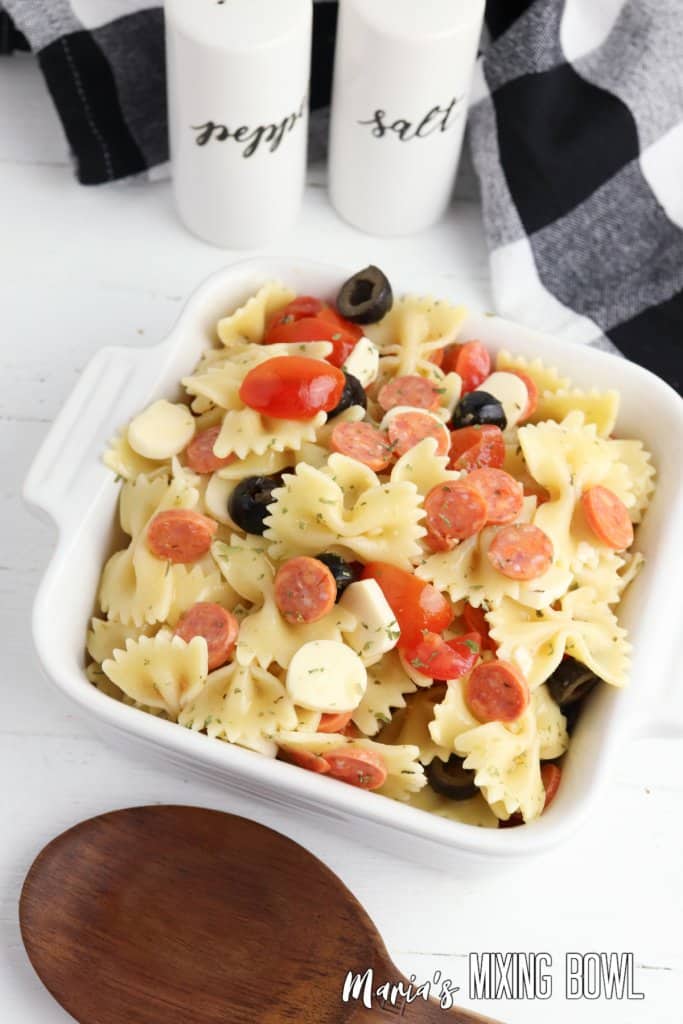 bowl of pepperoni pasta salad with a wooden spoon