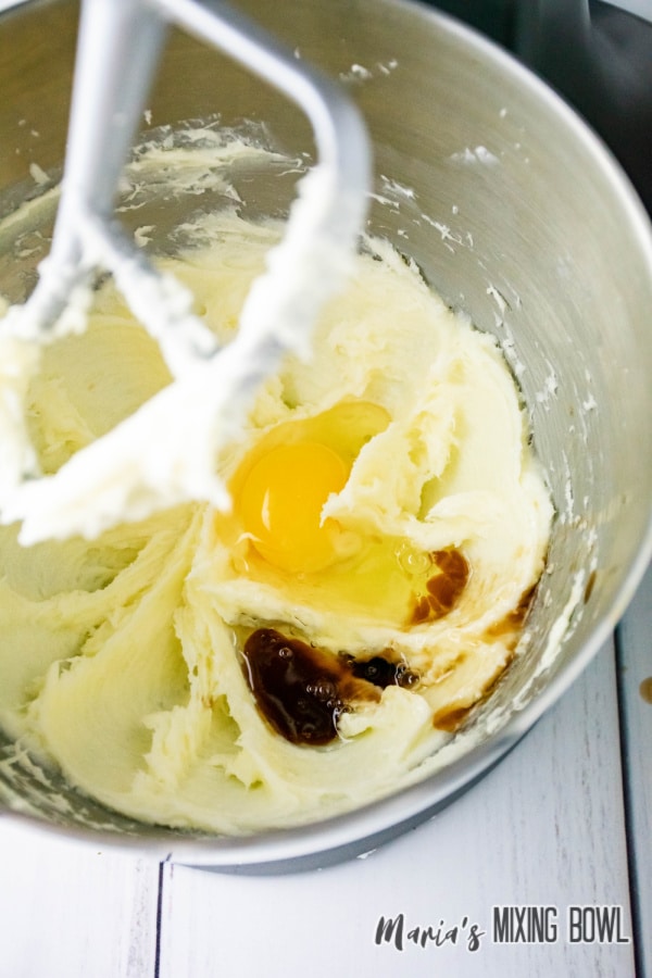 eggs and vanilla being being mixed into batter in a stand mixer