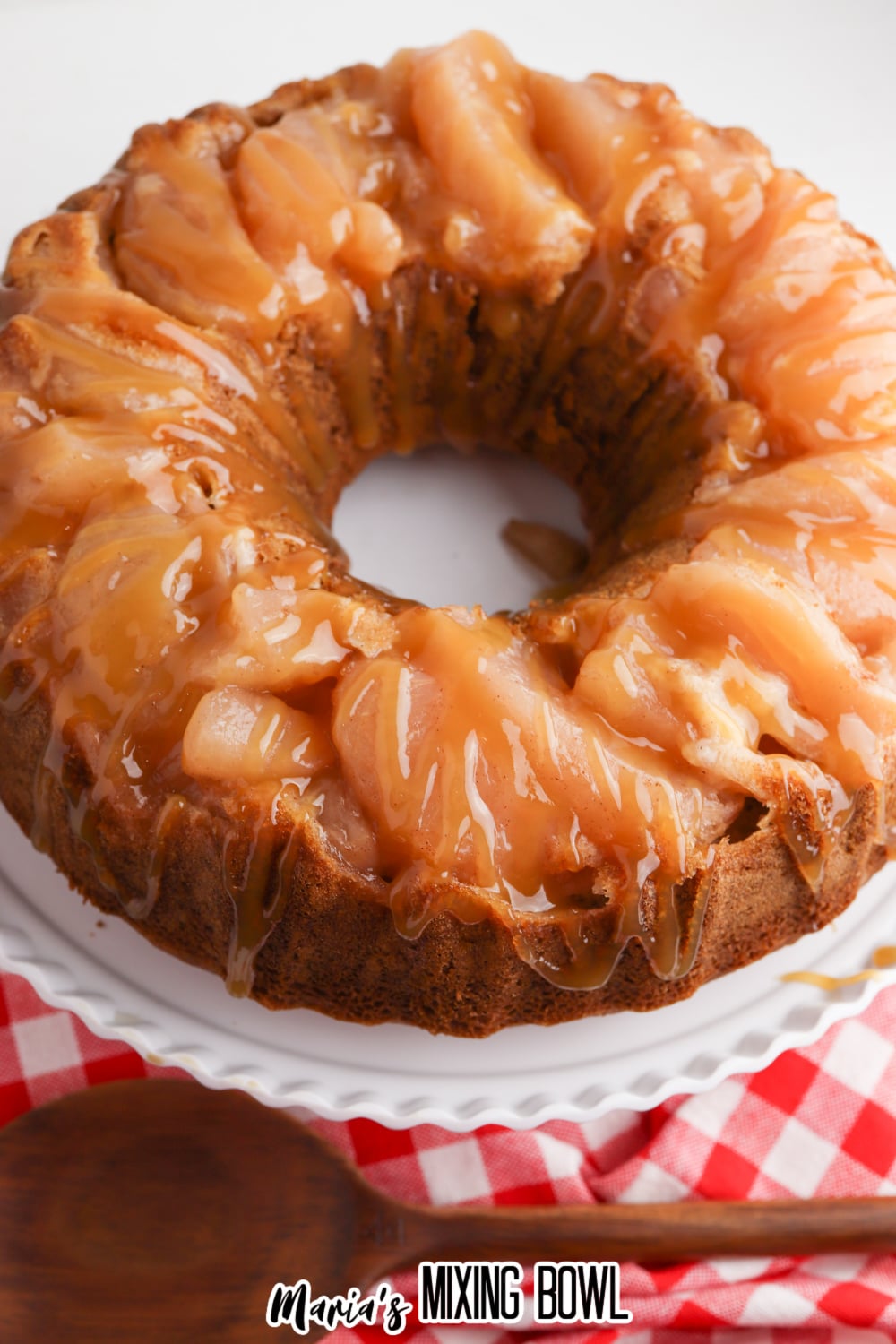 birds eye image of caramel apple upside day bundt cake on a white cake stand