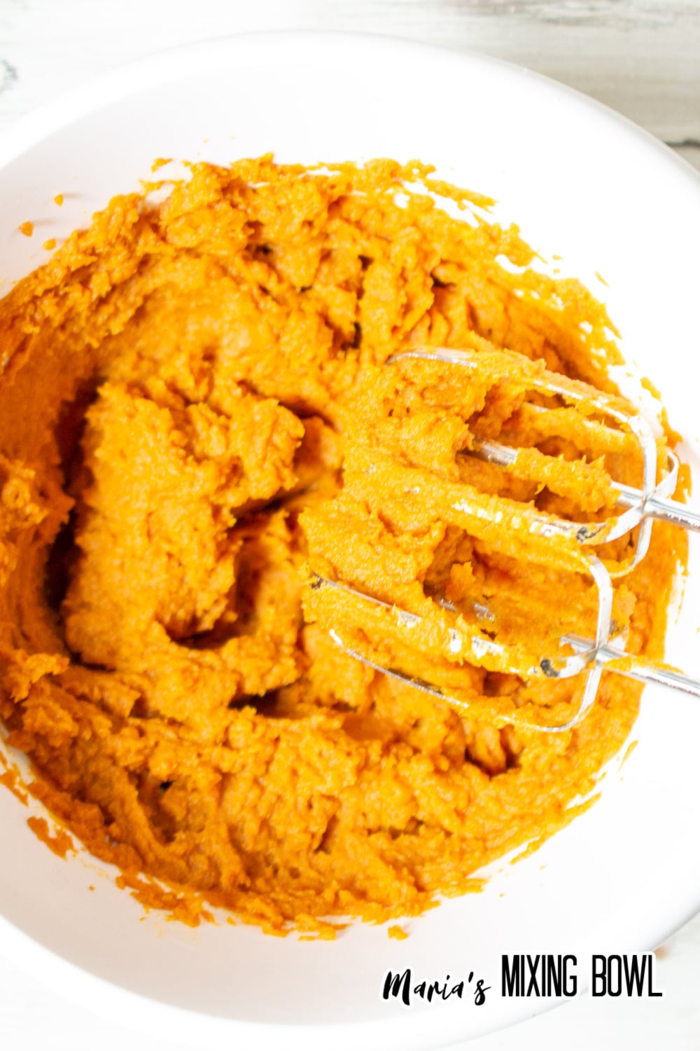 pumpkin and pudding mix being mixed in a white bowl