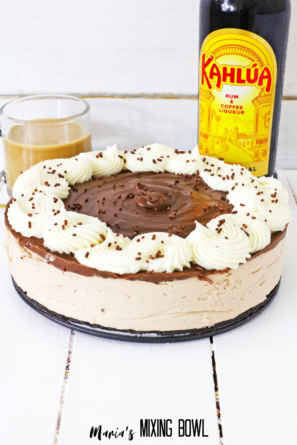 unsliced no bake kahlua cheescake with a bottle of kahlua in the background