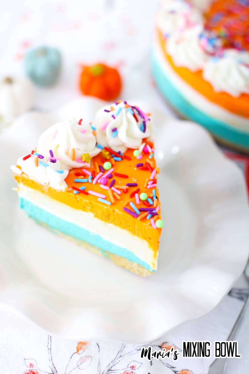 slice of no bake pumpkin cheesecake on a white plate topped with sprinkles