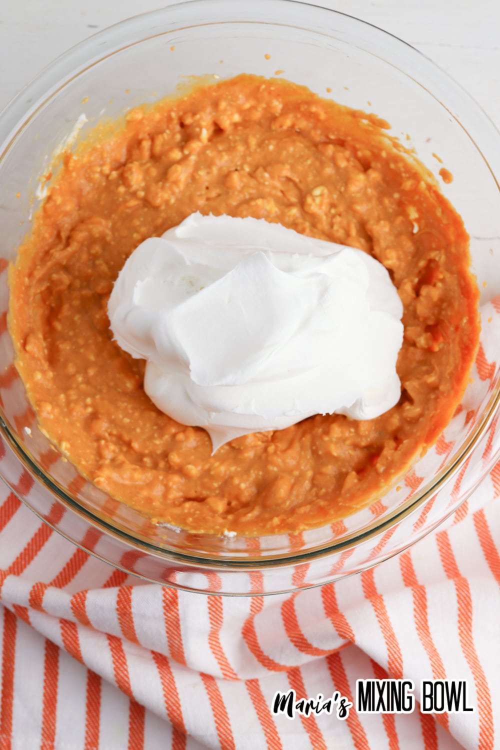 whipped topping and cheesecake mixture in a glass mixing bowl