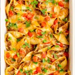 casesrole dish full of taco pasta shells in a white casserole dish with the name in text