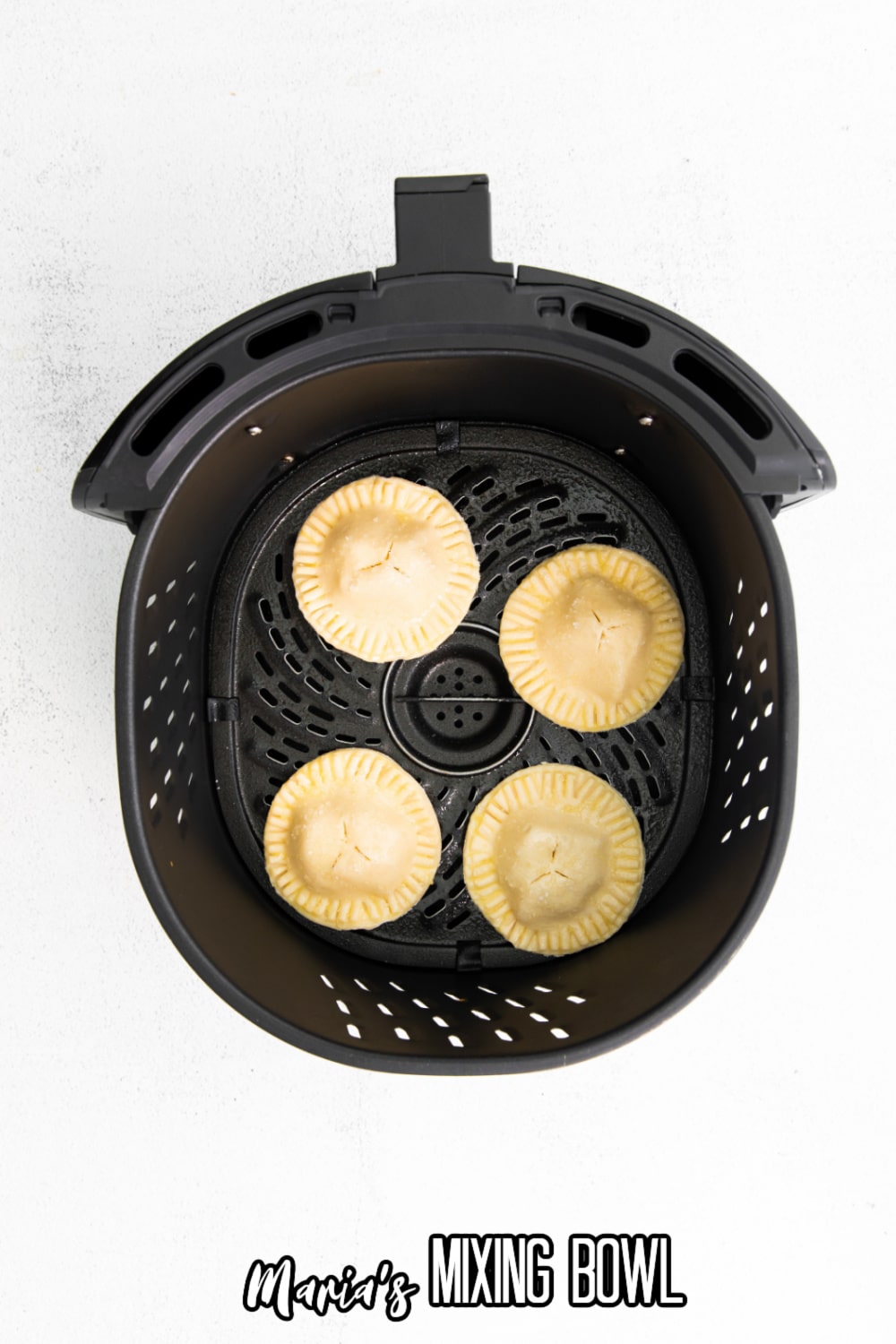 uncooked filled dough pockets in an air fryer basket