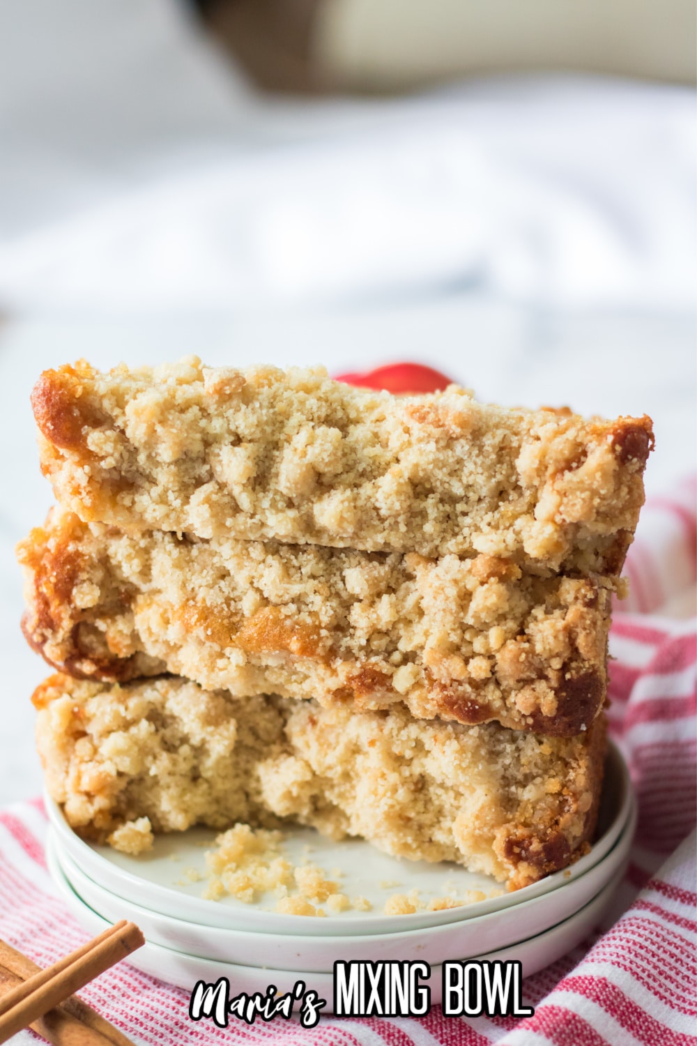 three slices of apple streusel cake on a small off white plate