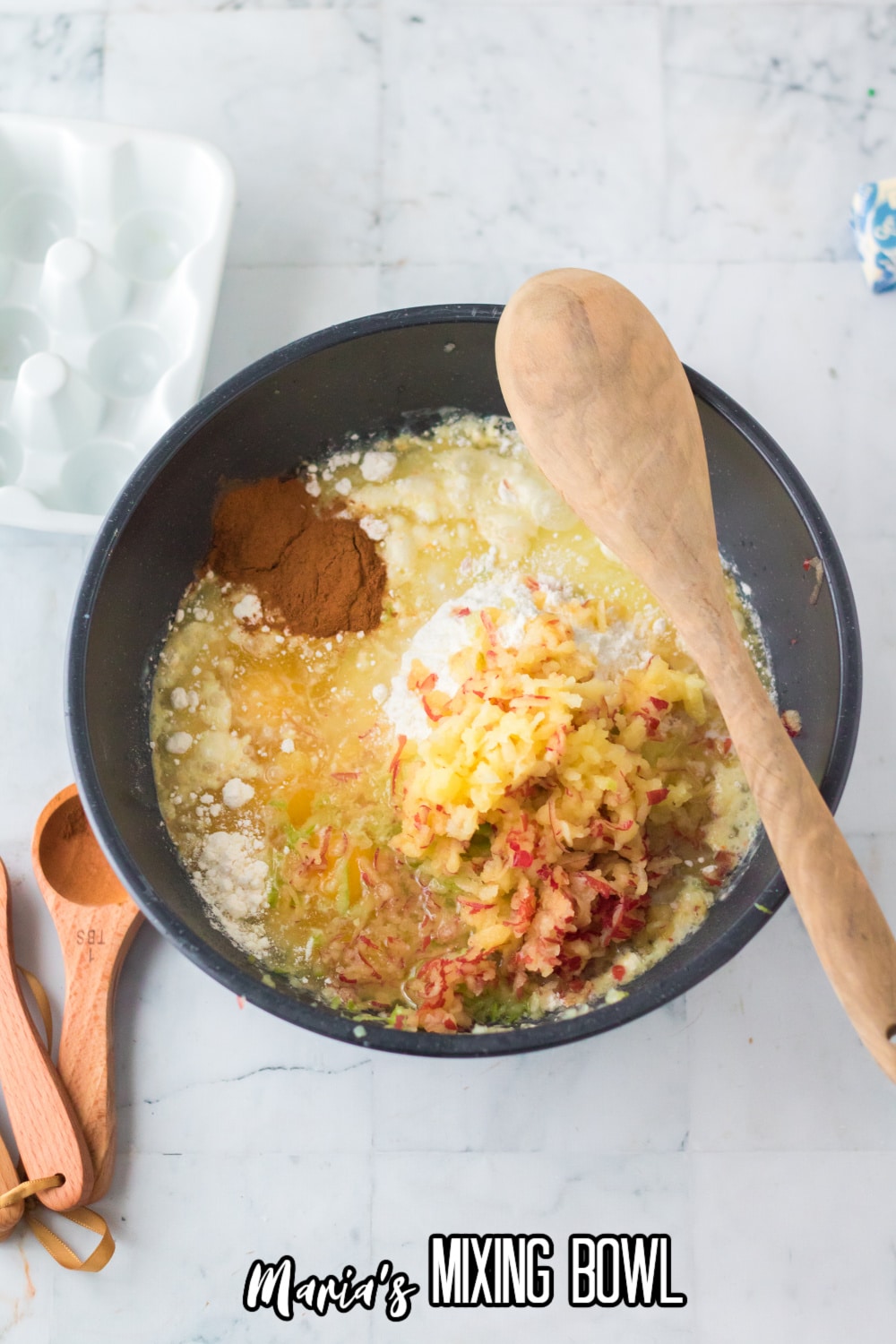 batter in a dark gray mixing bowl with a wooden spoon