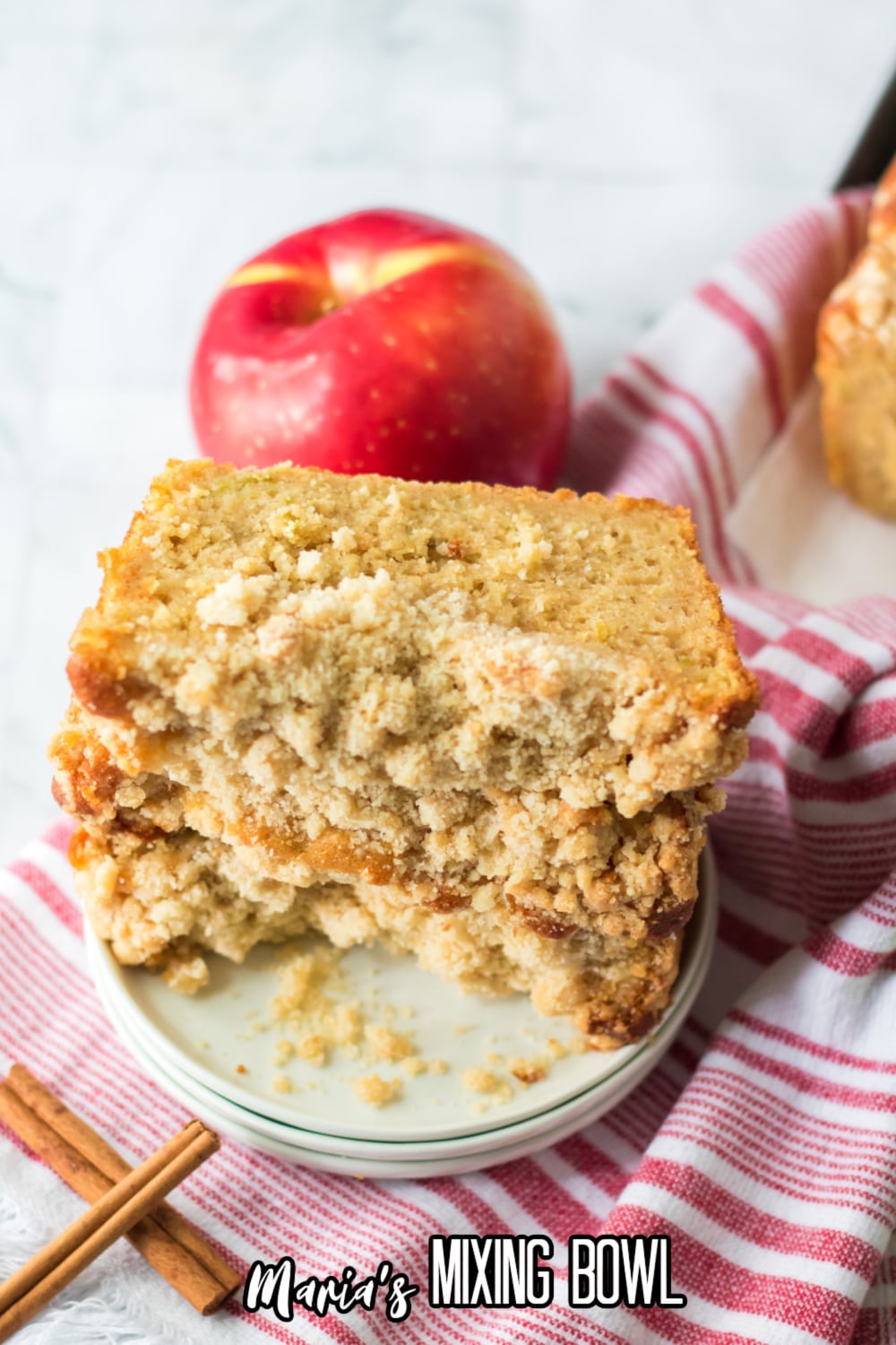 three slices of apple streusel cake on a small off white plate