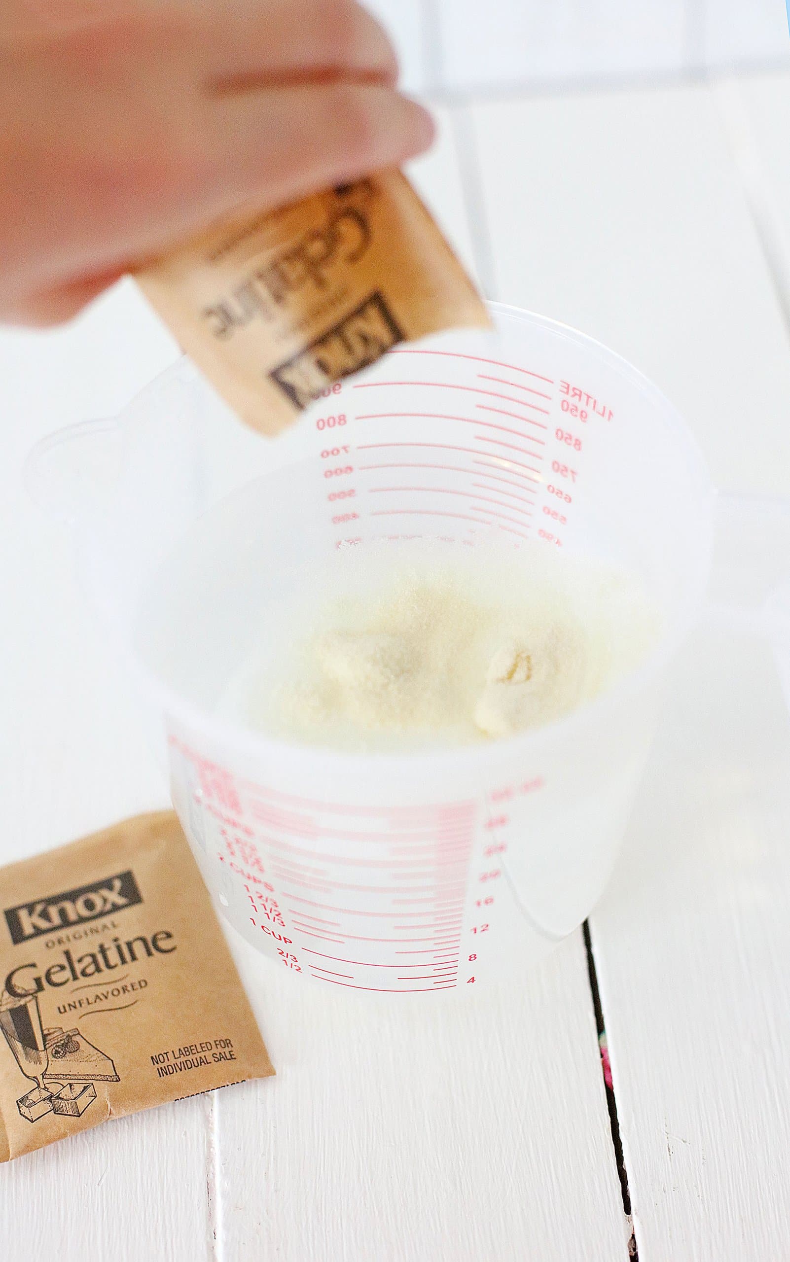 gelatin being mixxed in a plastic measuring cup